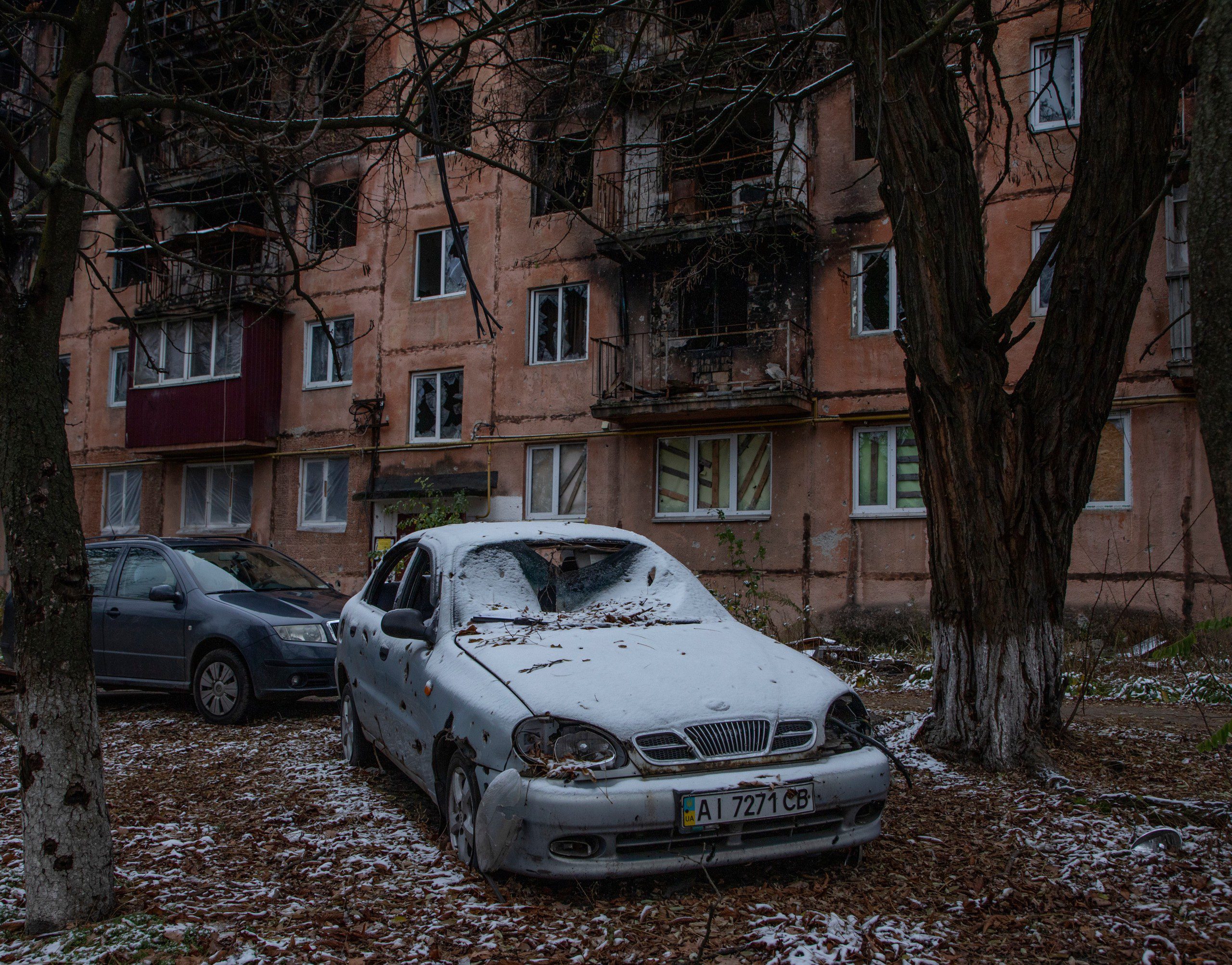 Photo of destroyed cars and apartment building in Irpin, Ukraine
